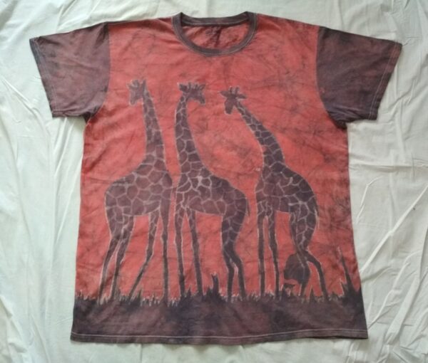 T-shirt batik pour homme. En face trois girafes et au dos deux girafes dont les cous sont croisés; rouge pâle. 76 x 49 cm.