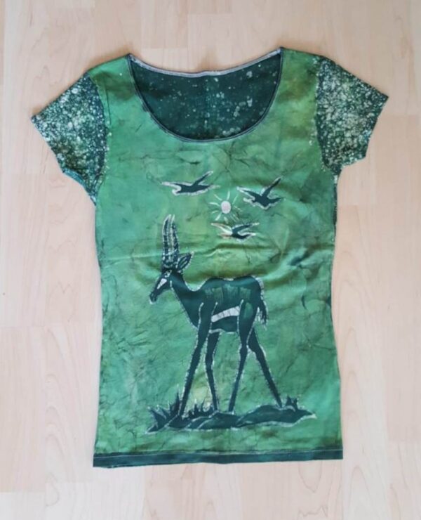 T-shirt batik for young lady. In front a gazelle, sun and birds and on the back the dotted lines, green. 52,5 x 32,5 cm.